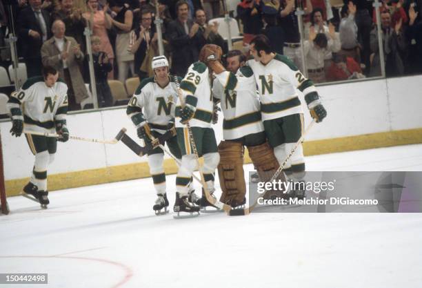Goalie Gump Worsley of the Minnesota North Stars celebrates with teammates Lou Nanne, Dean Prentice, Murray Oliver and Tom Reid after defeating the...