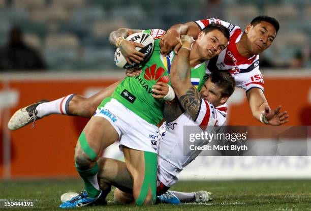 Sandor Earl of the Raiders is tackled during the round 24 NRL match between the Canberra Raiders and the Sydney Roosters at Canberra Stadium on...