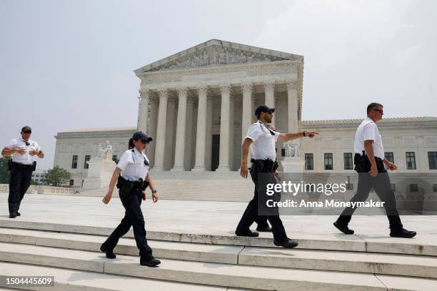 Police officers with the U.S. Supreme Court clear people from the sidewalk in front of the U.S. Supreme Court Building after alerts of a suspicious...