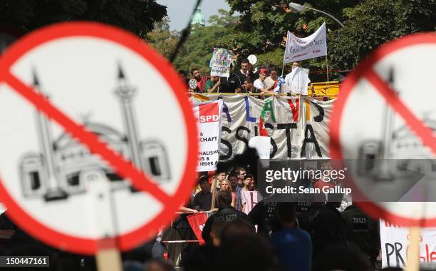 Supporters of the pro Deutschland right-wing anti-Islam group hold up signs showing a mosque with a red line through it as counter-demonstrators look...