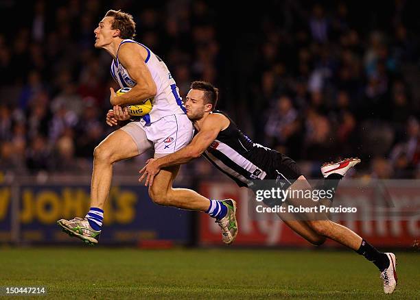 Drew Petrie of the Kangaroos takes a mark as Nathan Brown of the Kangaroos attempts to spoil during the round 21 AFL match between the Collingwood...
