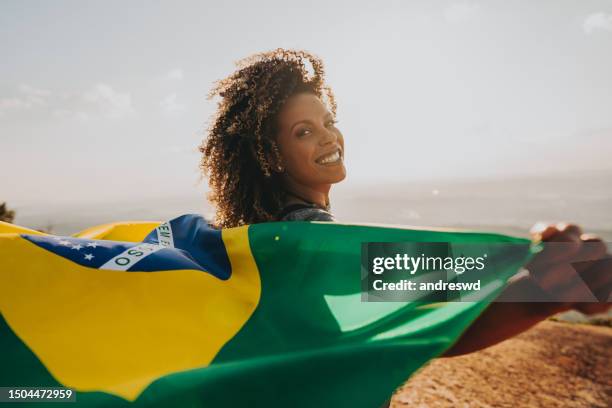 smiling woman with the flag of brazil - brazil flag stock pictures, royalty-free photos & images