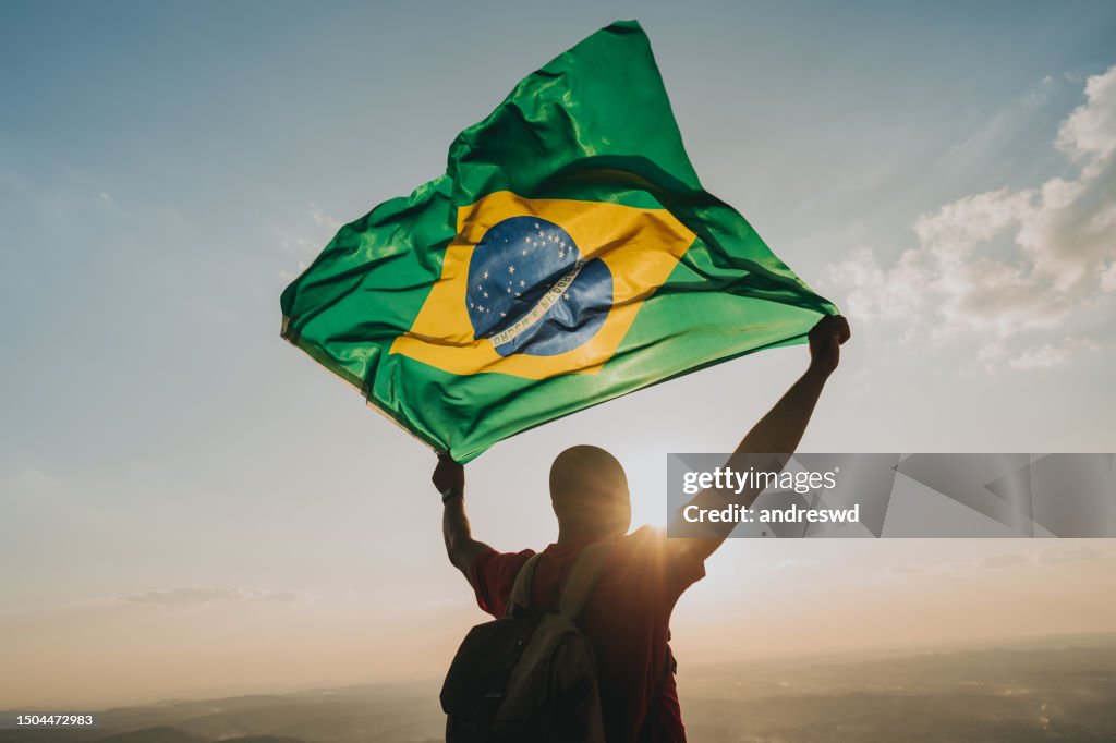 Man holding the flag of Brazil