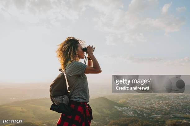 backpacker woman using binoculars - viewing binoculars stock pictures, royalty-free photos & images