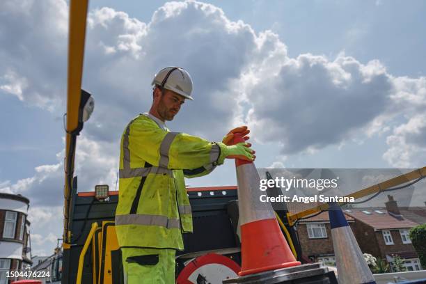 road safety first: worker moving traffic cones - wegenbouw stockfoto's en -beelden