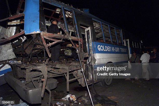 Philippine investigators inspect the interior of a bus after a bomb exploded at the rear of the bus October 18, 2002 in Manila. The bomb destroyed...