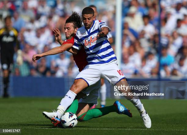 Adel Taarabt of QPR is tackled by Michu of Swansea during the Barclays Premier League match between Queens Park Rangers and Swansea City at Loftus...