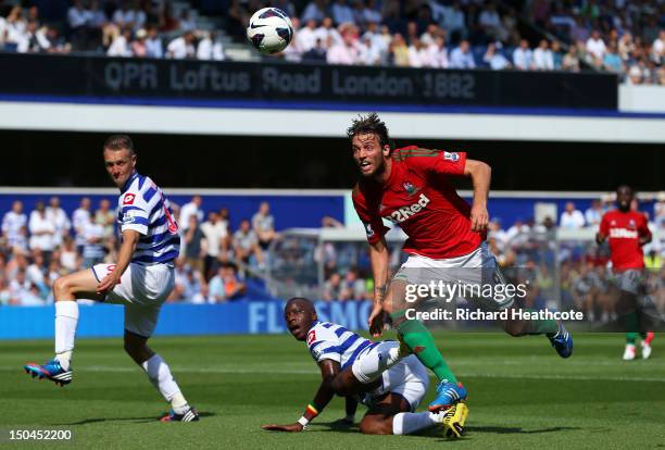 Michu of Swansea goes past Samba Diakite of QPR during the Barclays Premier League match between Queens Park Rangers and Swansea City at Loftus Road...