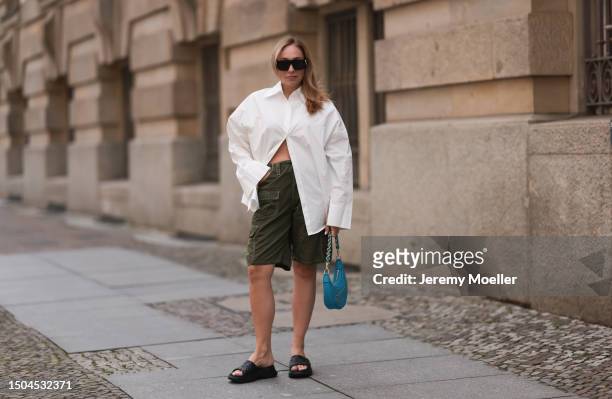 Sonia Lyson wearing Louis Vuitton rubber black logo monogram sandals, white Storets oversized buttoned long sleeve flannel, Zara khaki capri pants,...