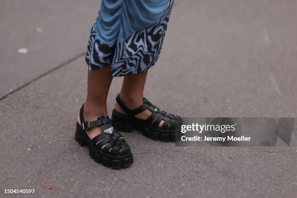 Fashion Week guest is wearing chunky black strap sandals from Prada outside Amiri Show during the Menswear Spring/Summer 2024 as part of Paris...