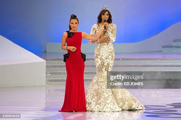 Miss World 2012 host Mylene Klass of Britain holds a microphone for Miss World 2011 winner Ivian Sarcos of Venezuela during the pageant's final...