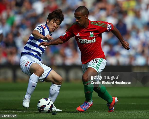 Wayne Routledge of Swansea holds off Park Ji-Sung of QPR during the Barclays Premier League match between Queens Park Rangers and Swansea City at...