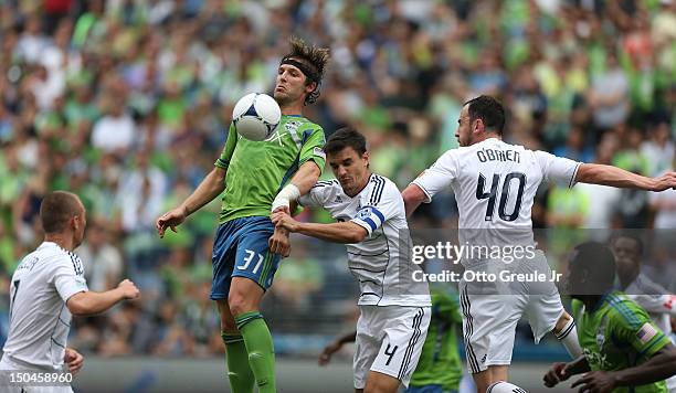 Jeff Parke the Seattle Sounders FC battles Alain Rochat of the Vancouver Whitecaps at CenturyLink Field on August 18, 2012 in Seattle, Washington....