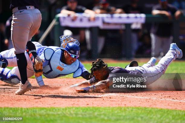 Jose Ramirez of the Cleveland Guardians steals home plate and scores the go ahead run past the tag from Salvador Perez of the Kansas City Royals...