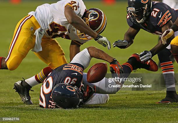 Julius Peppers of the Chicago Bears recovers a fumble as Major Wright and Alfred Morris of the Washington Redskins close in during a preseason game...