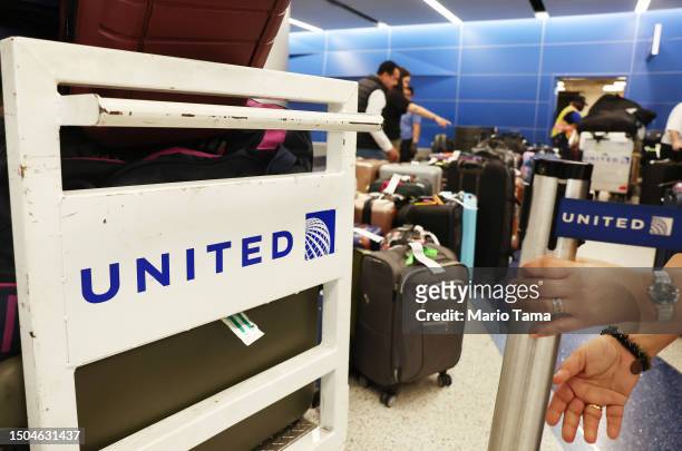 Traveler looks for baggage amid rows of unclaimed luggage at the United Airlines baggage claim area at Los Angeles International Airport on June 29,...