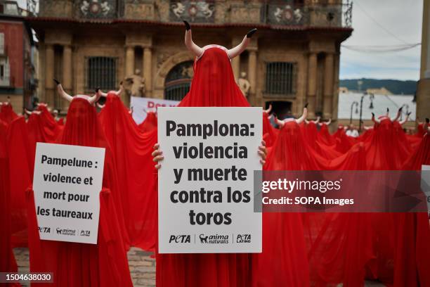 Peta, anti-bullfighting protesters seen holding placards expressing their opinion and wearing bull horns, during the protest held in Pamplona one day...