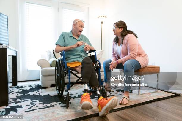 senior man with amputations gets help from nurse - diabetic amputation stock pictures, royalty-free photos & images