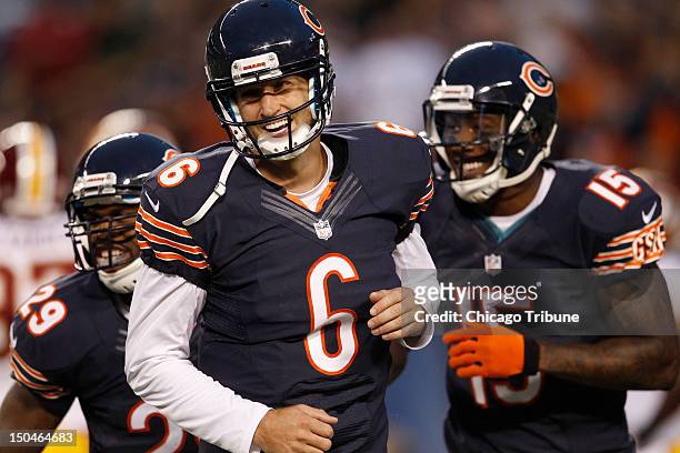 Left, Chicago Bears running back Michael Bush celebrates his touchdown against the Washington Redskins with teammates, Bears quarterback Jay Cutler...