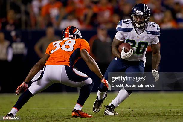 Running back Kregg Lumpkin of the Seattle Seahawks looks to make a move past cornerback Ramzee Robinson of the Denver Broncos during the fourth...