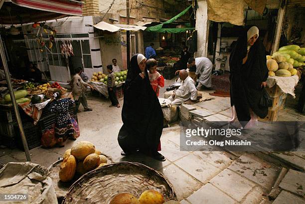 Iraqi women walk through a market street October 18, 2002 in the town known as Najaf, which is approximately 100 miles south of Baghdad, Iraq. Iraqi...