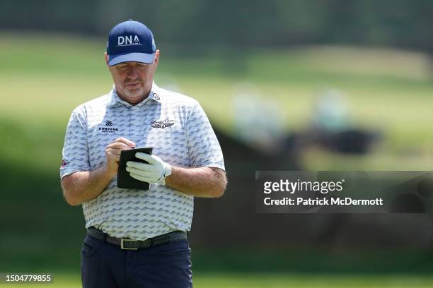 Rod Pampling of Australia writes in his yardage book on the sixth hole during the first round of the U.S. Senior Open Championship at SentryWorld on...