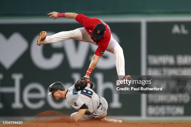 Joey Wendle of the Miami Marlins slides under a tag by Christian Arroyo of the Boston Red Sox during the ninth inning at Fenway Park on June 29, 2023...