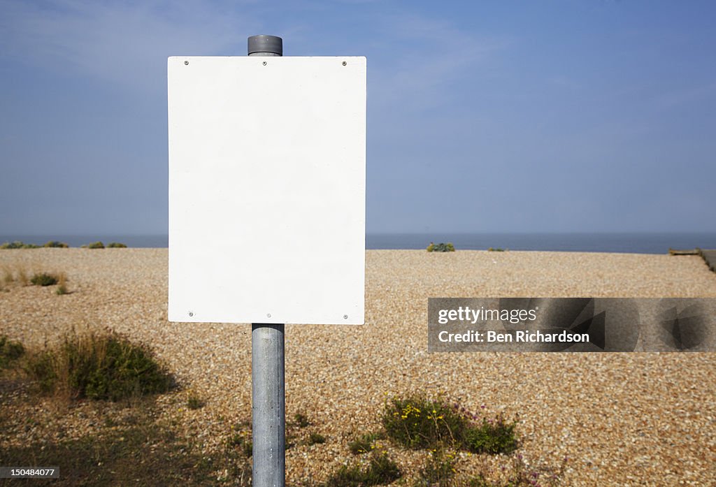A blank sign on the beach