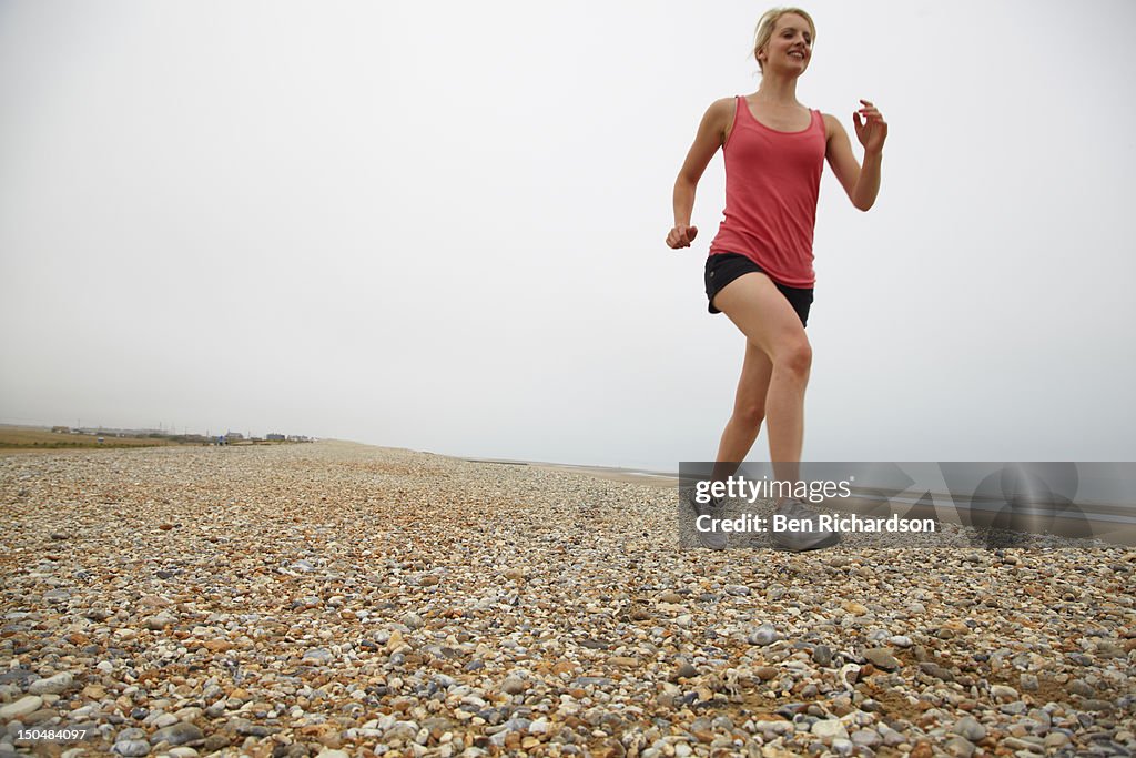 Young woman running next to sea
