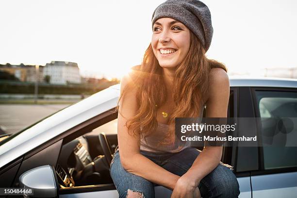 confidence woman sitting on car. - smiling controluce foto e immagini stock