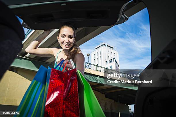 woman taking her shopping out of the trunk. - shopping bags car boot stock pictures, royalty-free photos & images