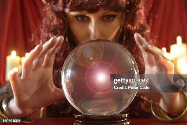 fortune teller looking into crystal ball - gypsy fotografías e imágenes de stock