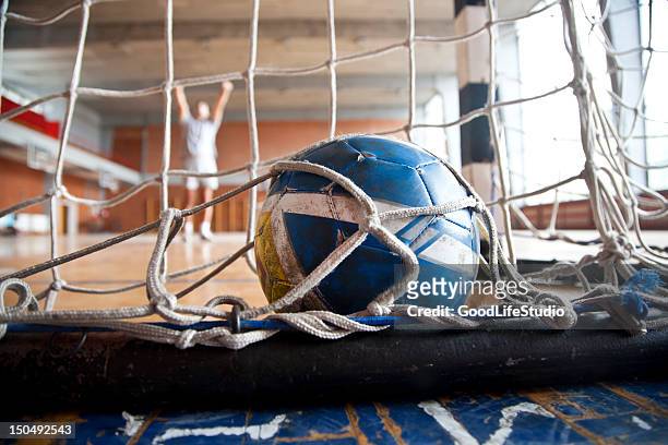 blue and yellow handball inside of goal net - handball stock pictures, royalty-free photos & images