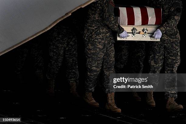 Army soldiers carry the flag-draped transfer case containing the remains of U.S. Army Spc. Richard A. Essex during a dignified transfer at Dover Air...