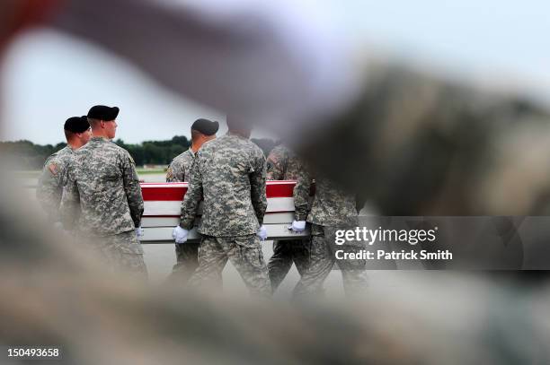 Army soldiers carry the flag-draped transfer case containing the remains of U.S. Army Spc. Richard A. Essex during a dignified transfer at Dover Air...