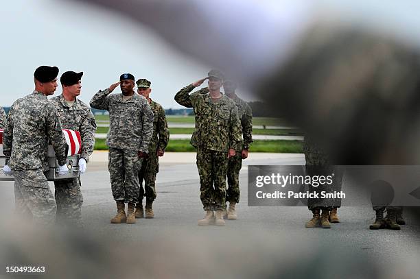 Army soldiers carry the flag-draped transfer case containing the remains of U.S. Army Spc. Richard A. Essex during a dignified transfer at Dover Air...