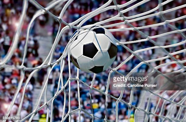 football, or soccer ball in the back of a net - américa del norte fotografías e imágenes de stock
