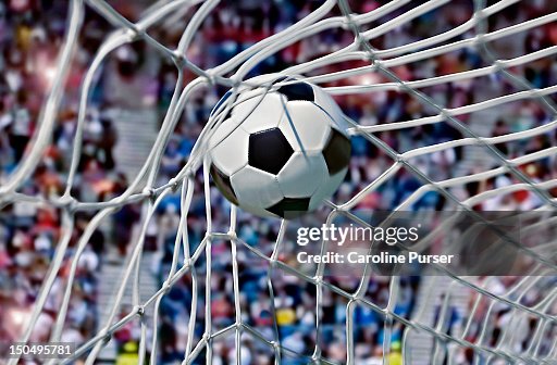 Football, or soccer ball in the back of a net Football, or soccer ball in the back of a net