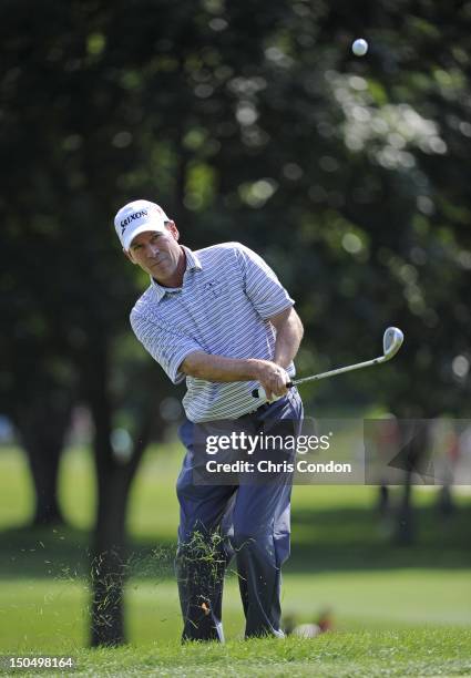 John Huston chips to the 8th green during the final round of the Dick’s Sporting Goods Open at En-Joie Golf Course on August 19, 2012 in Endicott,...