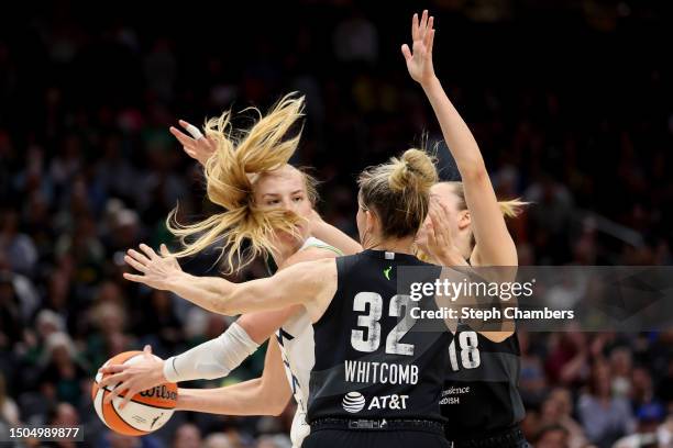 Dorka Juhasz of the Minnesota Lynx looks to pass while pressed by Sami Whitcomb and Ivana Dojkic of the Seattle Storm during the third quarter at...