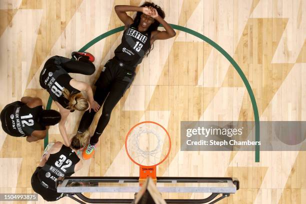 Ezi Magbegor of the Seattle Storm is tended to by teammates after an injury in overtime against the Minnesota Lynx at Climate Pledge Arena on June...