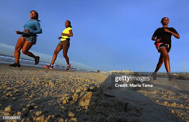 People jog at sunrise at Rockaway Beach on August 19, 2012 in the Queens borough of New York City. Over the last few years the Rockaways peninsula...
