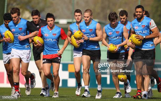 David Zaharakis, Nathan Lovett-Murray and their Bombers team mates run during an Essendon Bombers AFL training session at Windy Hill on August 20,...