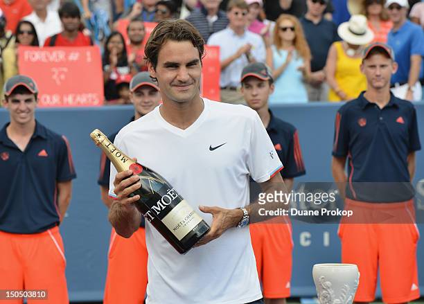 Roger Federer holds a bottle of Moet Champagne after winning his singles final match again Novak Djokovic during the debut of Moet & Chandon as the...