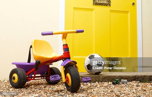 children's toys on the doorstep of a house - tricycle stock pictures, royalty-free photos & images