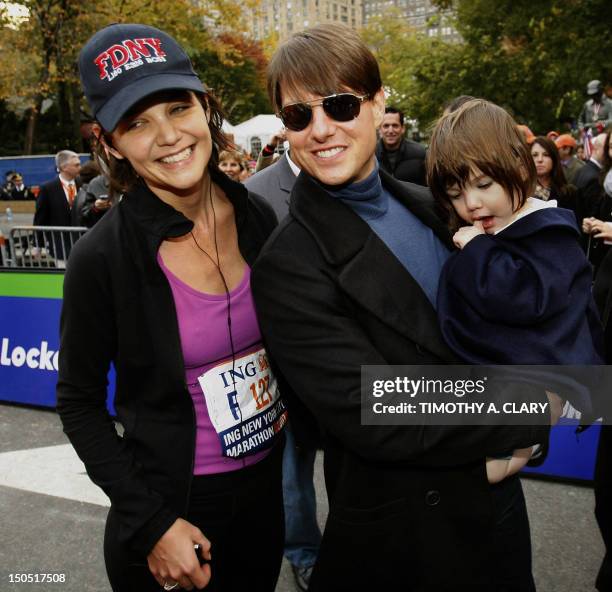 Actor Tom Cruise holding his daughter Suri greets his wife Katie Holmes after she finished running the New York City Marathon in New York 04 November...