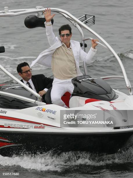 Accompanied by director J.J. Abrams , US actor Tom Cruise , waves to his fans from a boat upon their arrival at Japan premiere of his new movie...