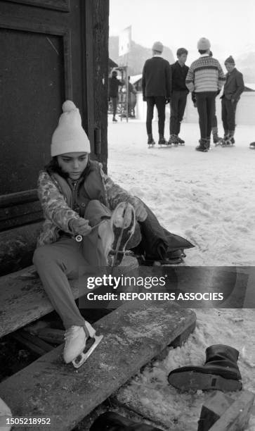 Liza Todd Burton enfilant des patins à glace à Gstaad, en 1965.