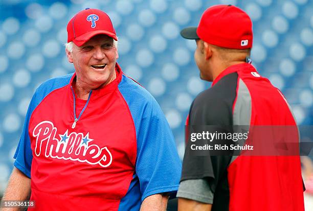Manager Charlie Manuel of the Philadelphia Phillies talks with Miguel Cairo of the Cincinnati Reds during batting practice before the start of a MLB...
