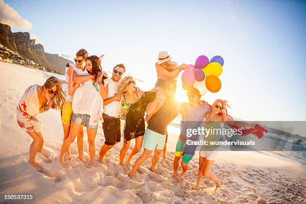 jeune groupe de personnes s'amuser à la plage - fête de plage photos et images de collection